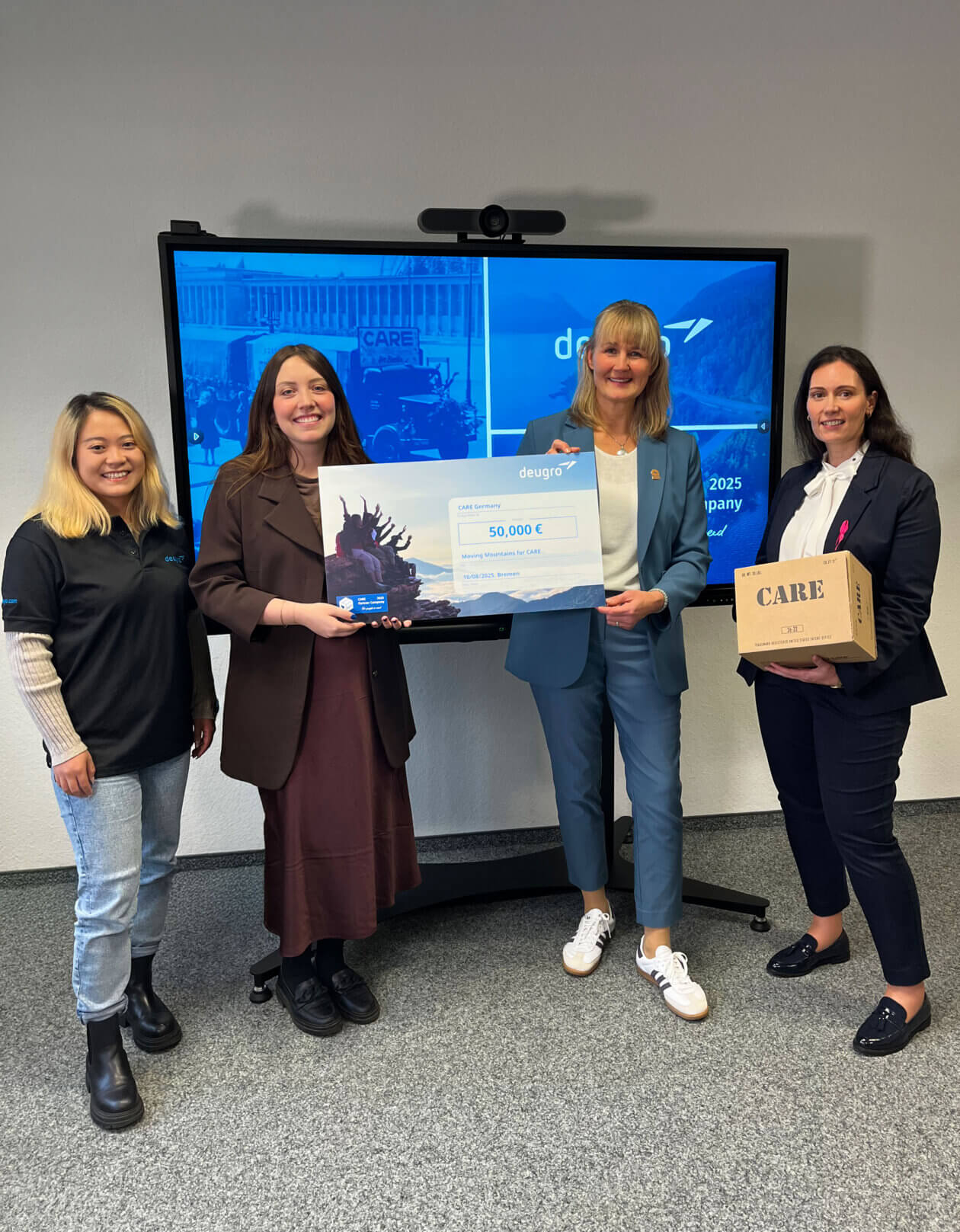 Silke Sommer, Chief Financial Officer; Ann-Cathrin van Looy, Head of Global Sustainability; and Jin Guo, Junior Sustainability Manager at deugro, present a €50,000 donation check to Judith Albert, Corporate Partnership Manager at CARE Germany.